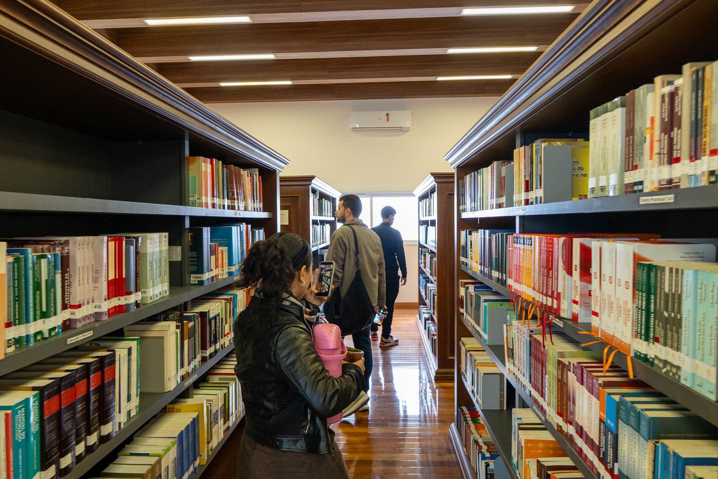 Participantes entre as estantes da biblioteca